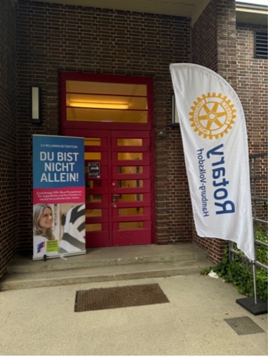 Blick auf den Eingang mit Banner und Rotary Club Fahne